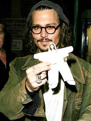Johnny Depp is happily flashing a paper doll that a 